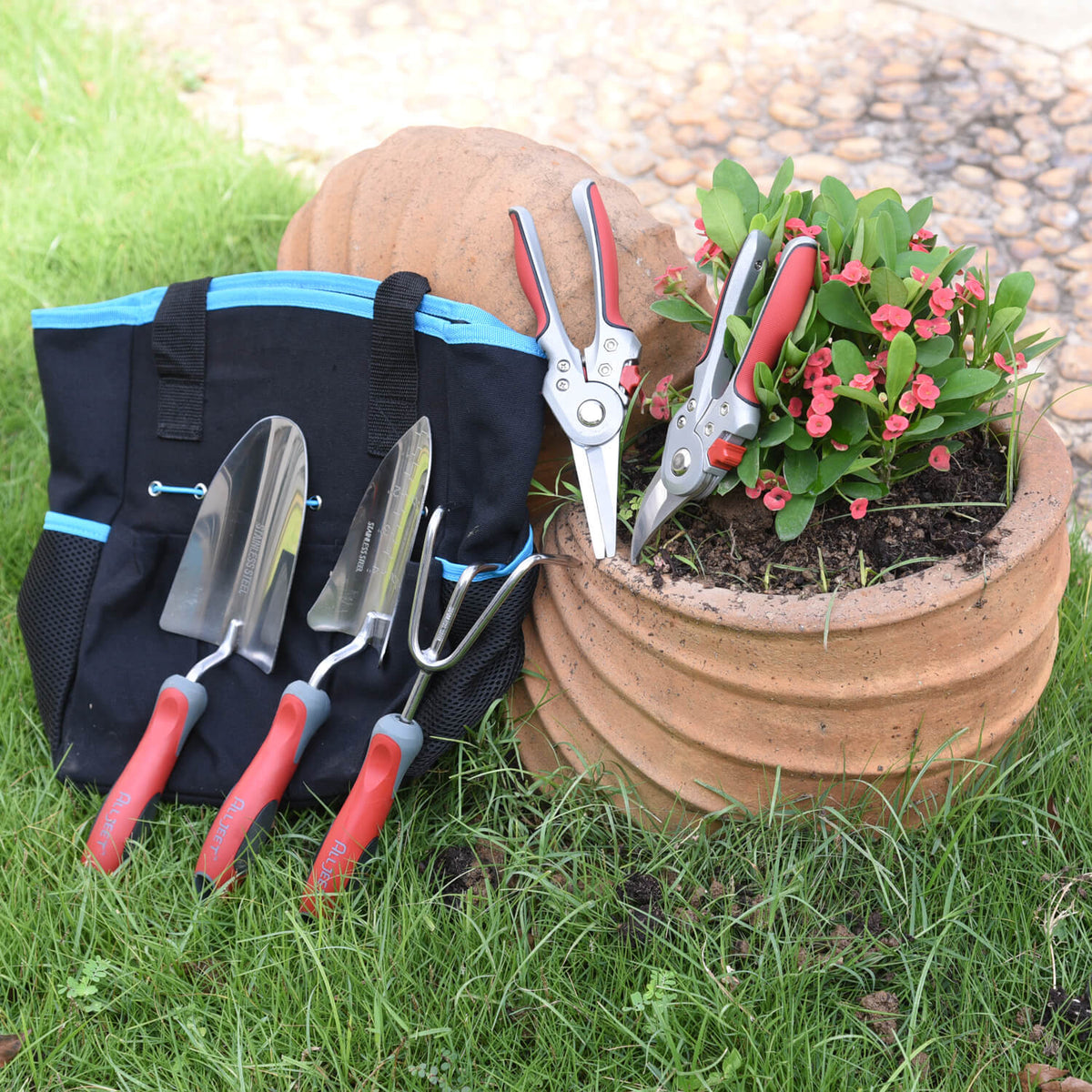 stainless steel garden tool set with storage bag near garden pot
